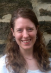 Photo of Deb Seltzer standing in front of a stone wall